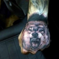 Black and gray style colored hand tattoo of evil wolf