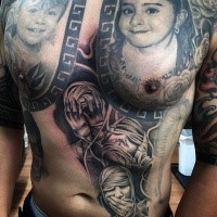 Black and gray style colored monster faces tattoo on belly