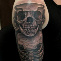 Black and gray style colored shoulder tattoo of ancient skeleton