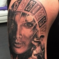 Black and gray style colored shoulder tattoo of roulette with human face