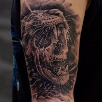 Black and gray style colored shoulder tattoo of creepy skull with cat skin helmet
