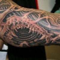 Black and gray style colored sleeve tattoo of alien teeth