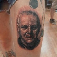 Schwarzer und grauer Stil farbiges Oberschenkel Tattoo von Hannibal Lecters Porträt