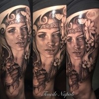 Black and gray style colored thigh tattoo of woman with flowers