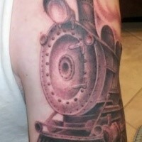 Black and gray style colored upper arm tattoo of steam train