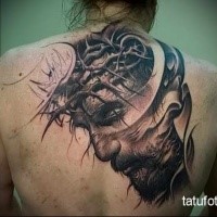 Black and gray style detailed back tattoo of Jesus face with vine