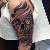 Black and gray style detailed shoulder tattoo of human skull with clock