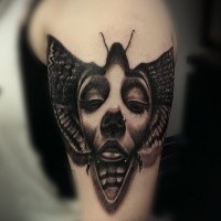 Black and gray style detailed shoulder tattoo of insect with woman face