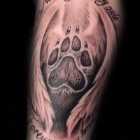Black and gray style detailed tattoo of animal paw print with wings and lettering