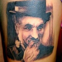 Black and gray style detailed thigh tattoo of Charlie Chaplin
