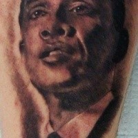 Schwarzer und grauer Stil detailliertes junges Obamas Gesicht Tattoo am Bein