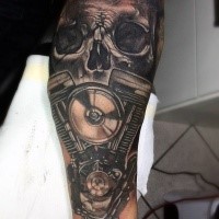 Schwarzer und grauer Unterarm Tattoo mit menschlichem Schädel und Motor