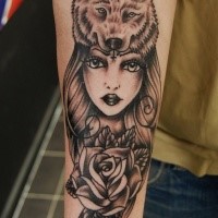 Black and gray style forearm tattoo of woman with rose and wolf helmet