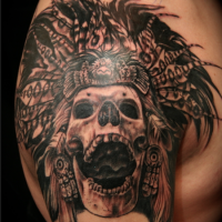 Black and gray style shoulder tattoo of ancient tribal skeleton with helmet