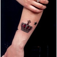 Black and red crown tattoo on hand
