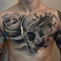 Black and white chest tattoo of human skull with heart and rose