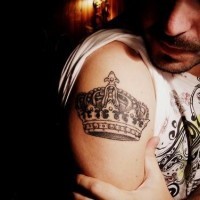 Black and white crown tattoo on shoulder