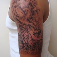Black-and-white dove with sun and lettering tattoo on upper arm