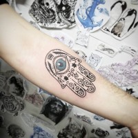 Schwarzweißes Hamsa Hand Unterarm Tattoo mit originalem Design und blauem Auge