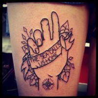 Tatuaje en el muslo,  mano con banner  y hojas, dibujo monocromo