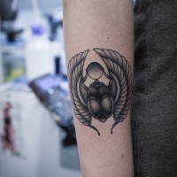 Black and white scarab tattoo on forearm in Egyptian style