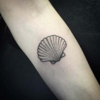 Black and white shell tattoo on forearm area