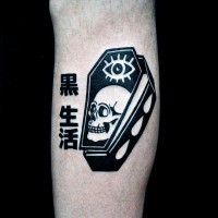 Tatuaje en el brazo, ataúd negro con ojo y cráneo y jeroglíficos