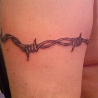 Black barbed wire tattoo on arm