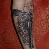 Tattoo von schwarzgrauer altmodischer Pistole am Unterarm