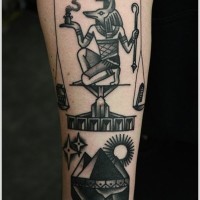 Black ink anubis and scales forearm tattoo