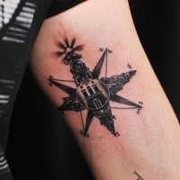 Black ink arm tattoo of nautical star stylized with castle