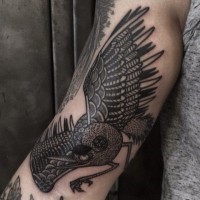 Tatuaje en el brazo, ave detallada negra