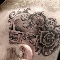 Black ink cartoon style head tattoo of humans skull with rose