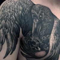 Black ink chest and shoulder tattoo of big creepy crow