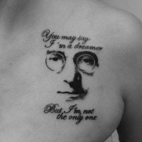 Black ink chest tattoo of Lennon with lettering