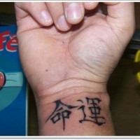 Schwarze Tinte chinesische Hieroglyphen Tattoo am Handgelenk
