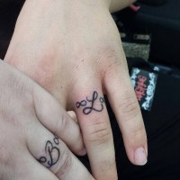 Tatuajes en los dedos para pareja enamorada, 
iniciales con símbolos de infinito diminutos
