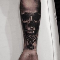 Black ink detailed looking forearm tattoo of human skull with clock