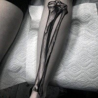 Black ink engraving style leg tattoo of human bone