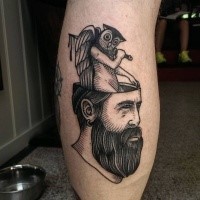 Black ink engraving style mystical man head with demonic owl tattoo on leg leg muscle