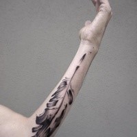 Black ink forearm tattoo of big feather