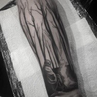 Black ink forearm tattoo of forest with man and fire