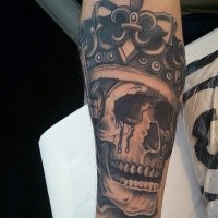 Black ink forearm tattoo of skeleton king