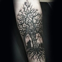Black ink forearm tattoo of tree with lettering