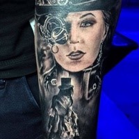 Black ink forearm tattoo of woman with mechanical eye