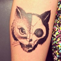 Tatuaje en el brazo, mitad gato mitad cráneo