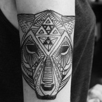Black ink head of an animal tattoo on arm