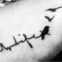 Black ink heart rhythm stylized with lettering life and black birds tattoo