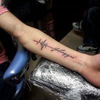 Black ink heart rhythm tattoo with lettering on arm