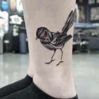 Black ink illustrative style leg tattoo of small bird
